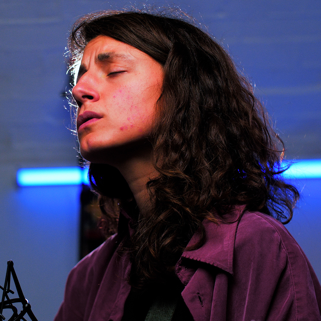 Sophie Jamieson sings soulfully under a blue light