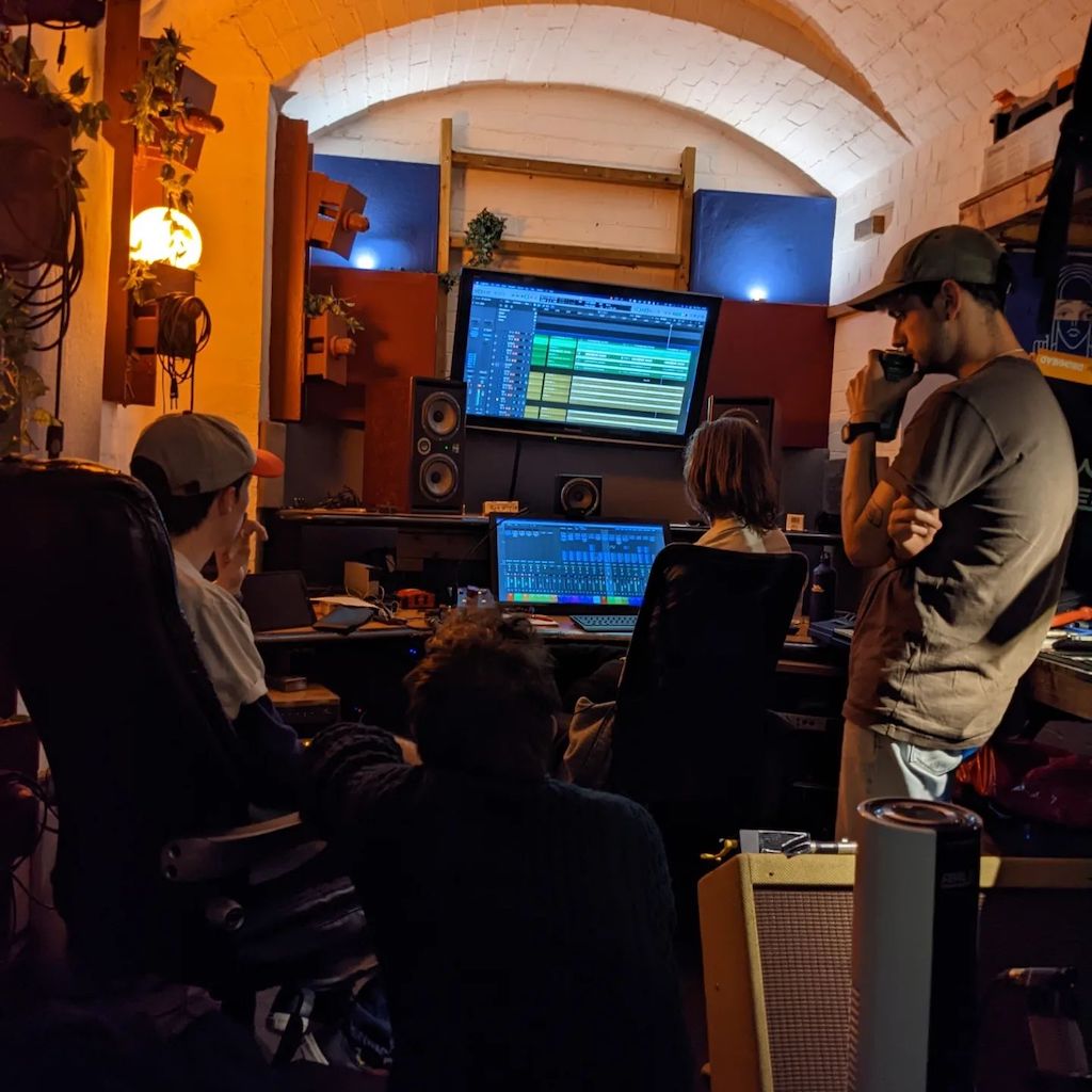 A band huddle in the control room to listen through takes