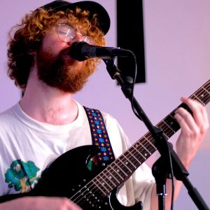 JW Francis playing a guitar and singing
