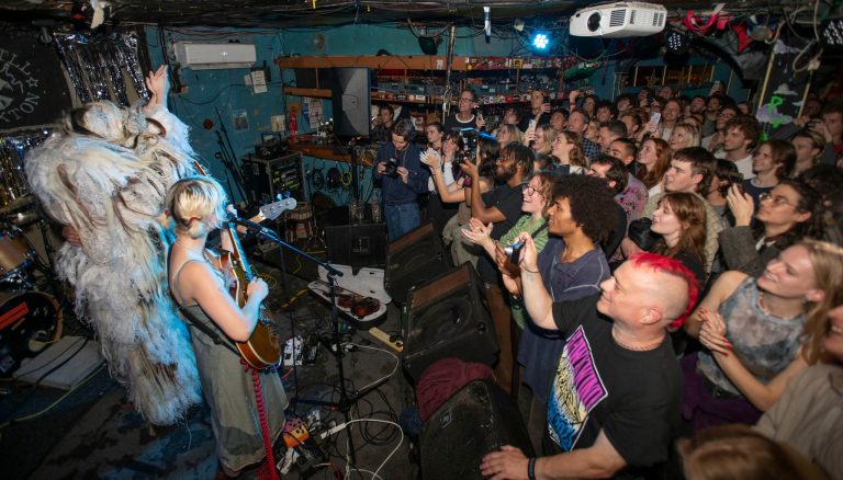 Shot of a gig in progress inside the windmill, brixton hill, full crowd facing two people on stage in the left of the picture